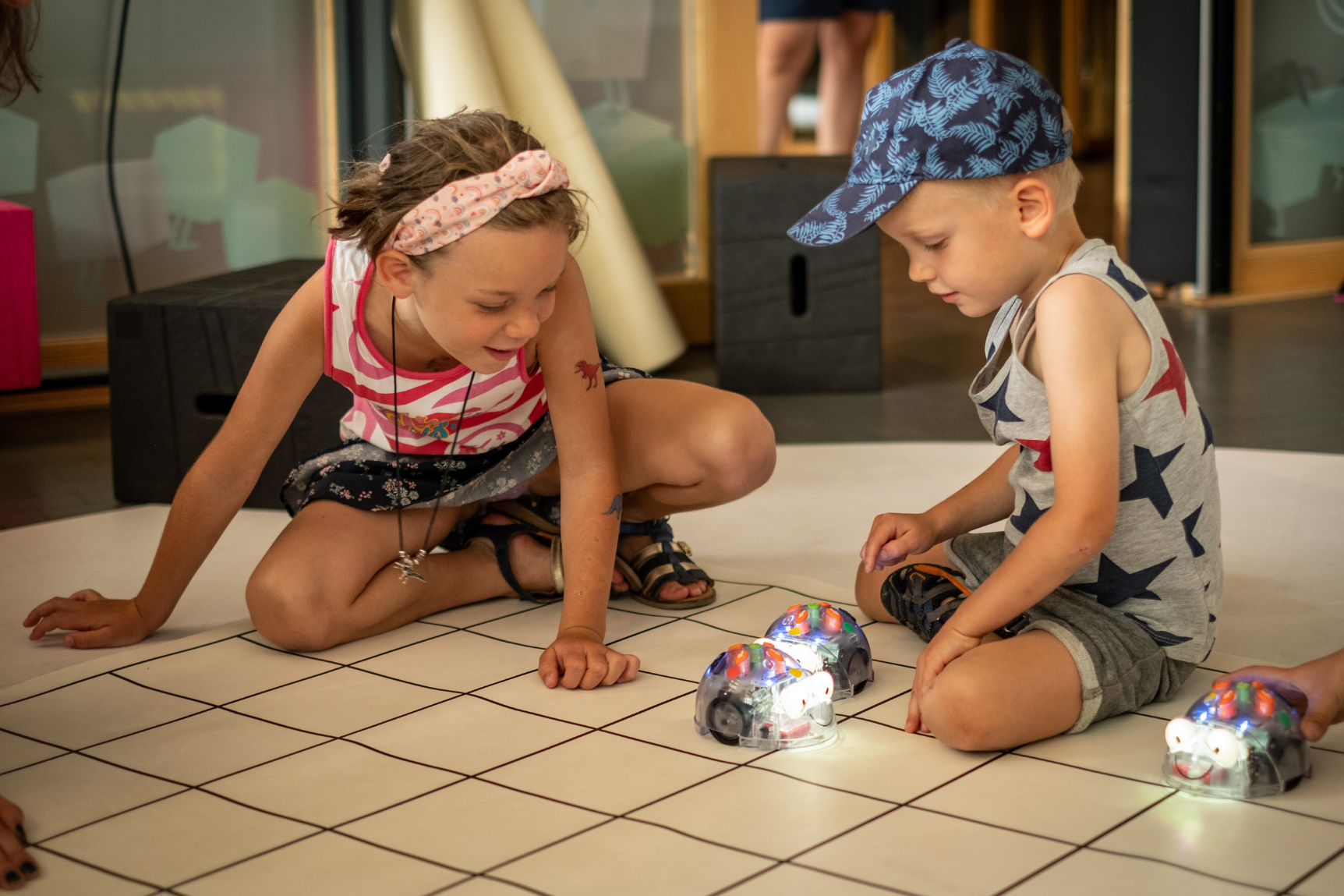Zwei Kinder spielen mit zwei leuchtenden Robotern 