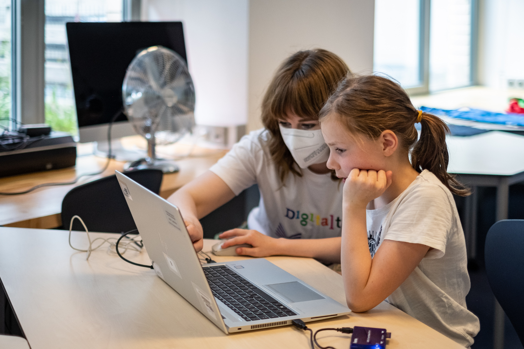 Eine Frau und ein Mädchen programmieren zusammen an einem Laptop