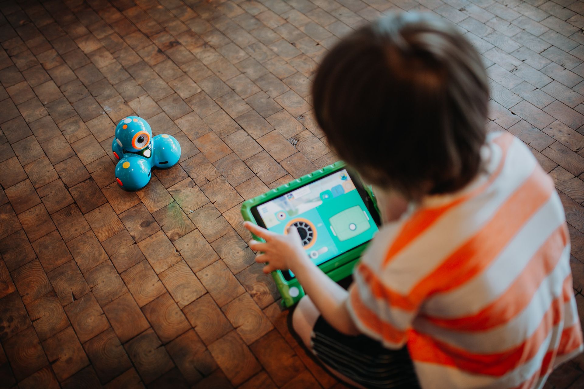 Ein Kind lenkt einen Roboter über ein Tablet