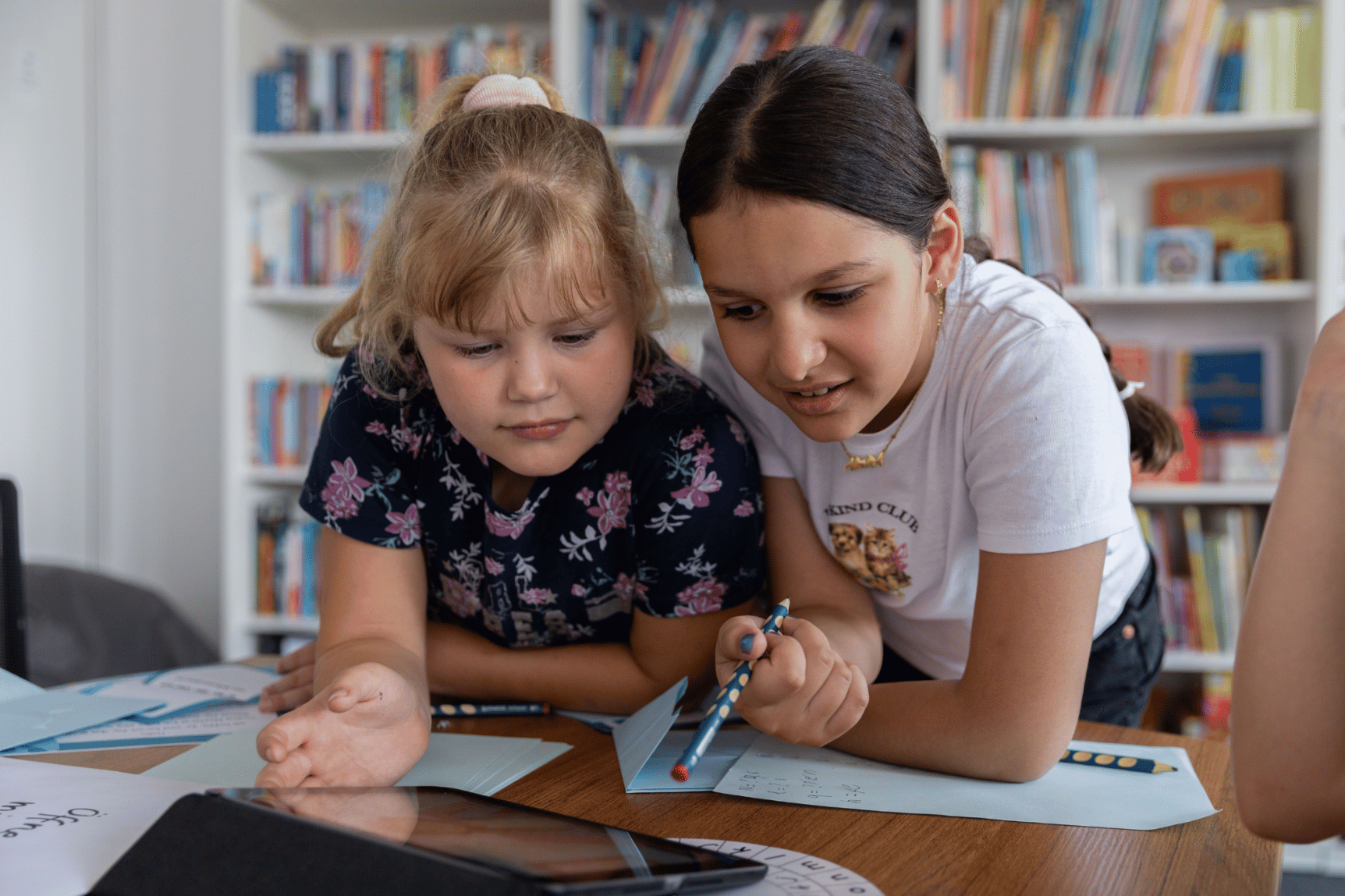 Zwei Mädchen bei einem Coding-Workshop schauen sich etwas auf einem Tablet an