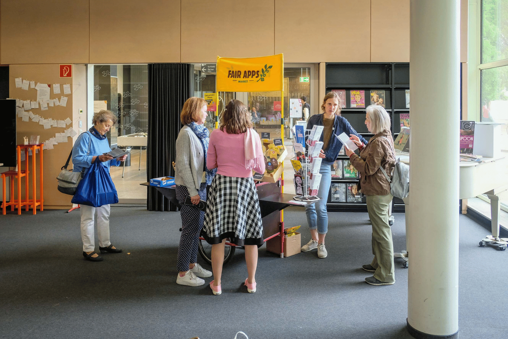 Besucherinnen und Besucher an einem Stand in einer Bibliothek