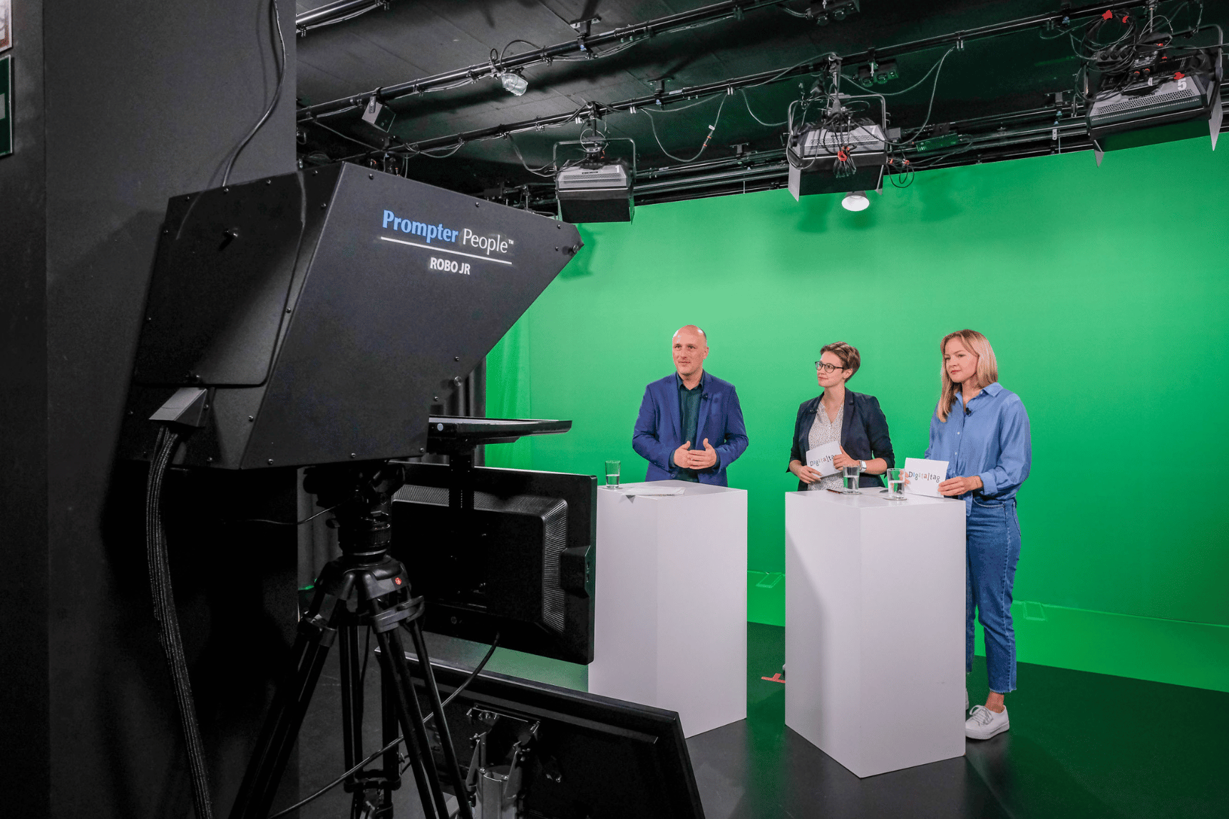 Staatssekretär im Bundesfamilienministerium Sven Lehmann wird mit zwei Moderatorinnen vor einem Green Screen gefilmt