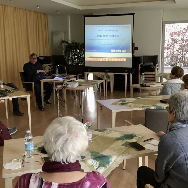 Beratungstreffen des Vereins: Ein Mann zeigt eine Präsentation; Seniorinnen und Senioren hören zu.