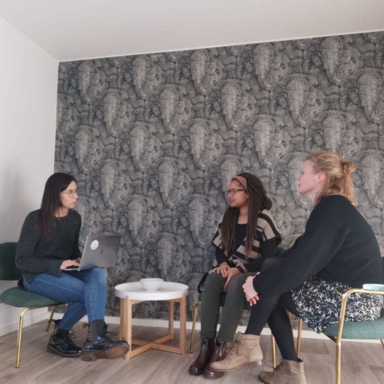 Drei Frauen sitzen zusammen und unterhalten sich