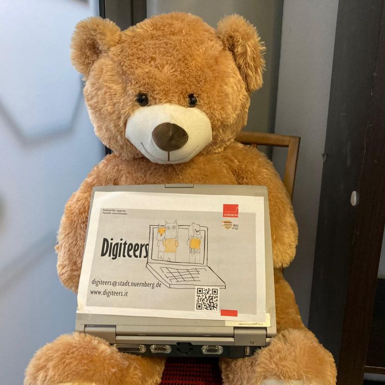 Ein Teddybär, der einen Laptop von Digiteers auf dem Schoß hält