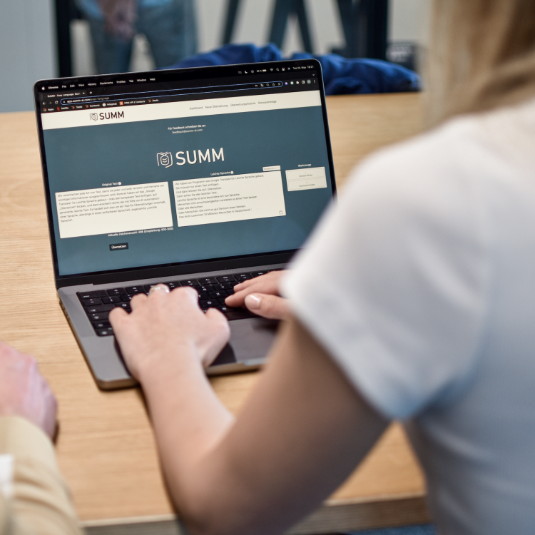 Eine Frau benutzt am Laptop das SUMM AI Tool