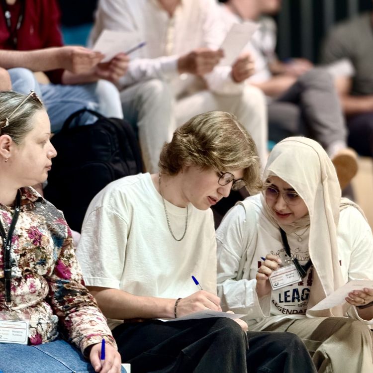 Foto von sitzenden Menschen bei einer Veranstaltung, die sich unterhalten.