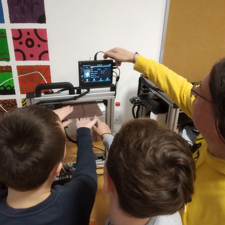 Eine Gruppe Kinder experimentiert an einer Maschine beim Community-Hacking im Jugendzentrum